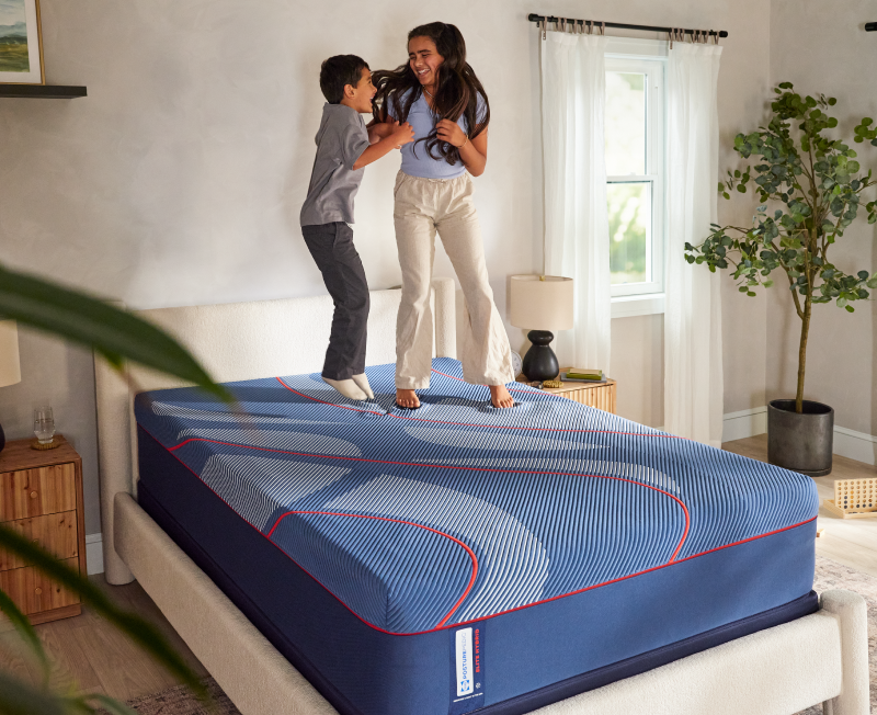 Girl and boy jumping on a mattress.
