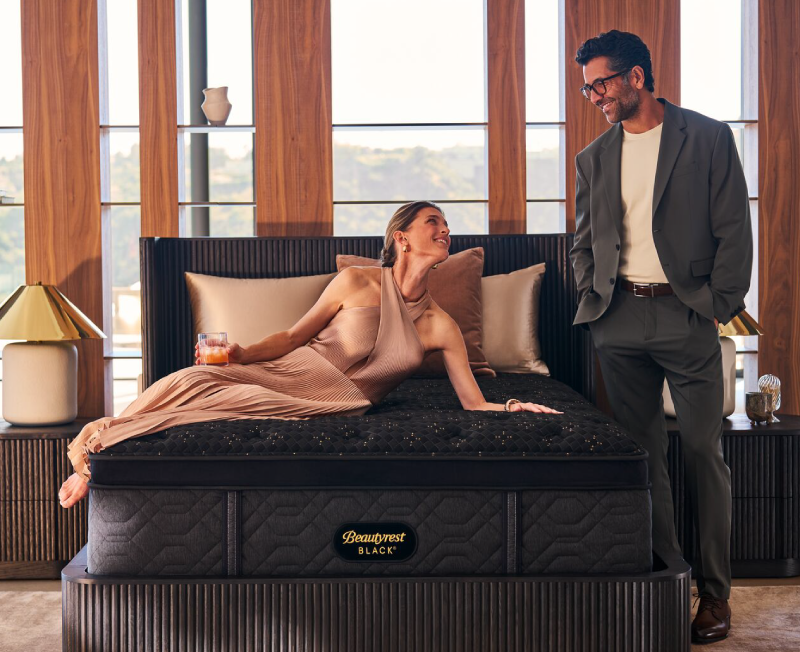 Couple standing near a mattress.