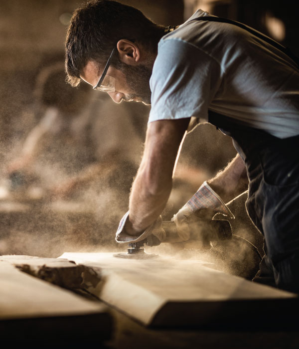 Man in a workshop repairing furniture.
