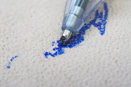 Pen ink has spilled on fabric.