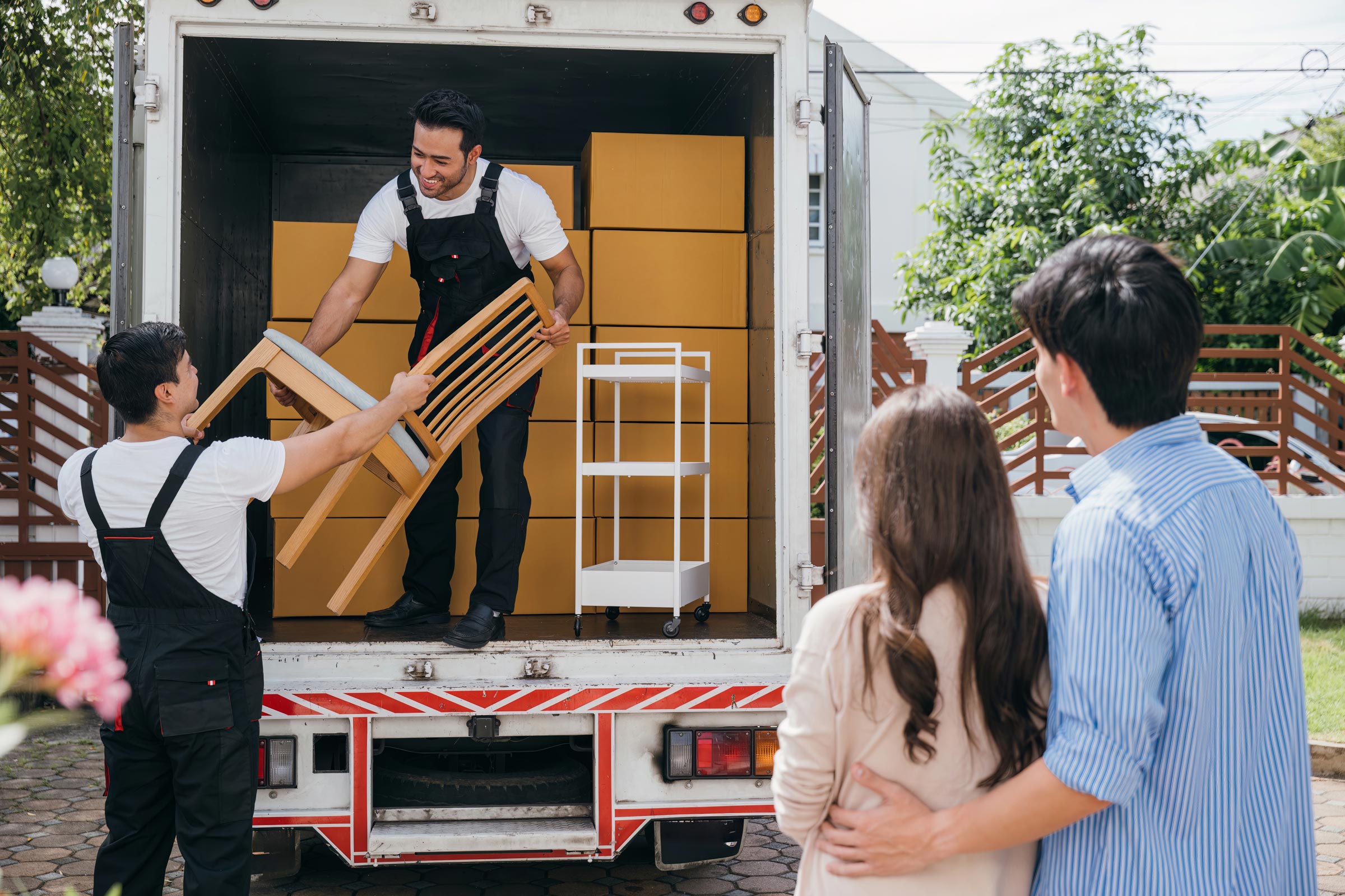 Two delivery workers taking furniture out of a truck.