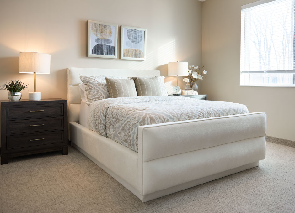 A serene bedroom with an upholstered platform bed and layered bedding
