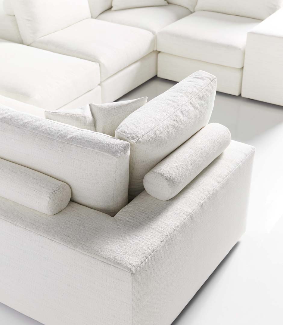 Corner of white couch with pillows