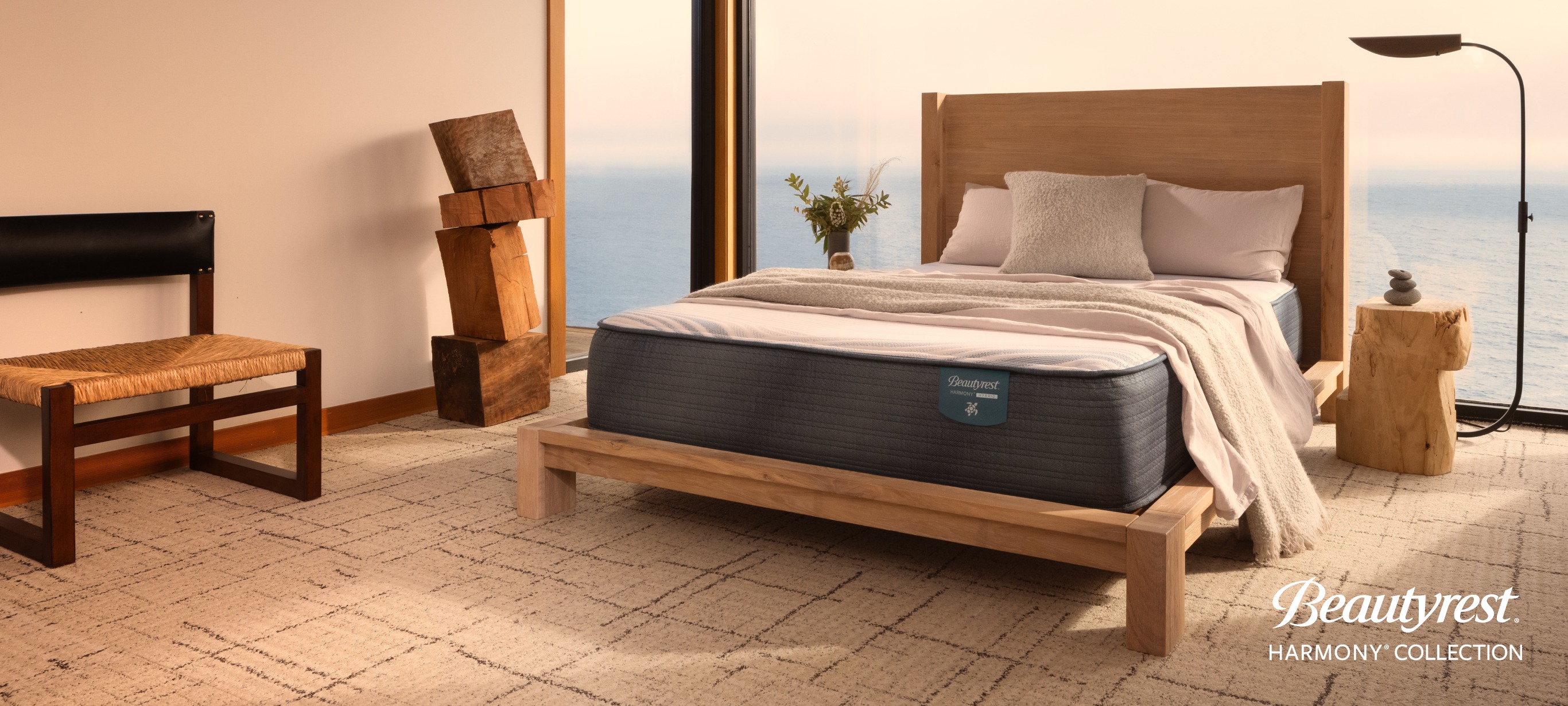 A queen size Beautyrest mattress in a bedroom overlooking the sea.