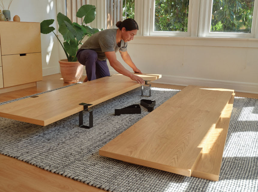 Woman setting up Floyd Bed Frame