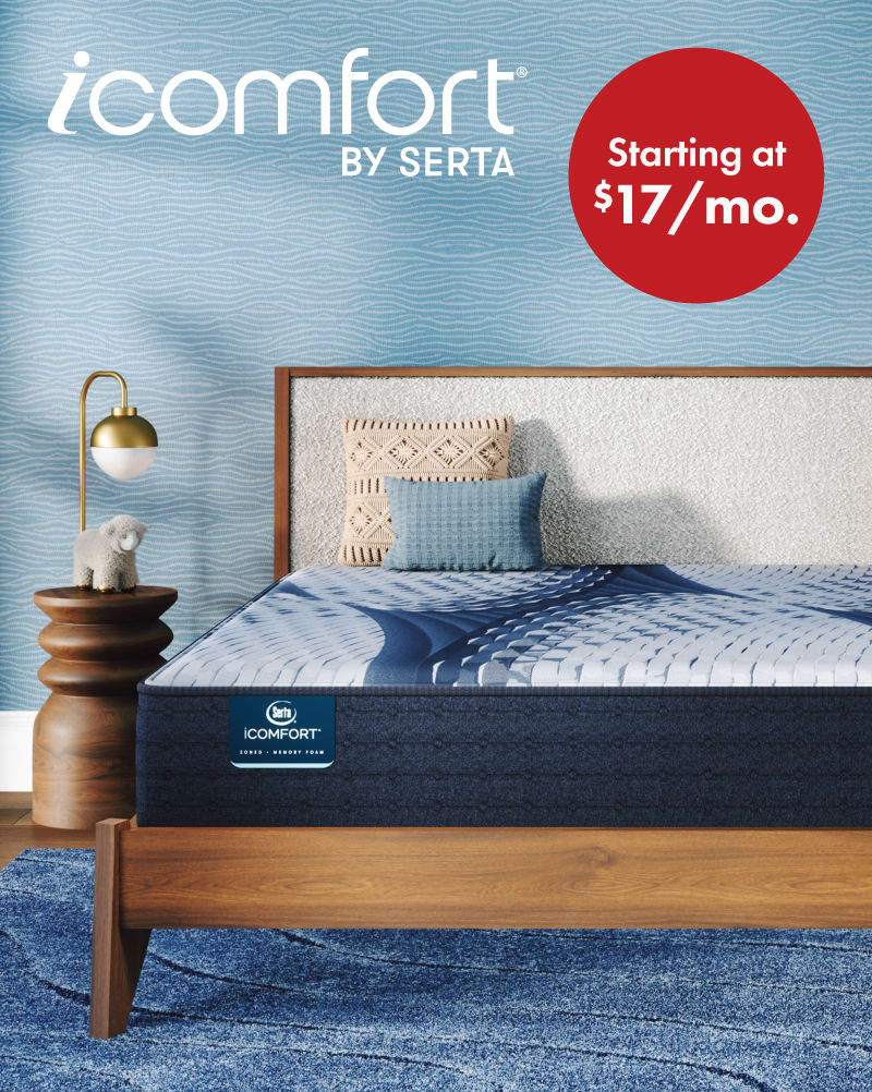 A queen size Serta iComfort mattress on a brown wooden bed in a bedroom.