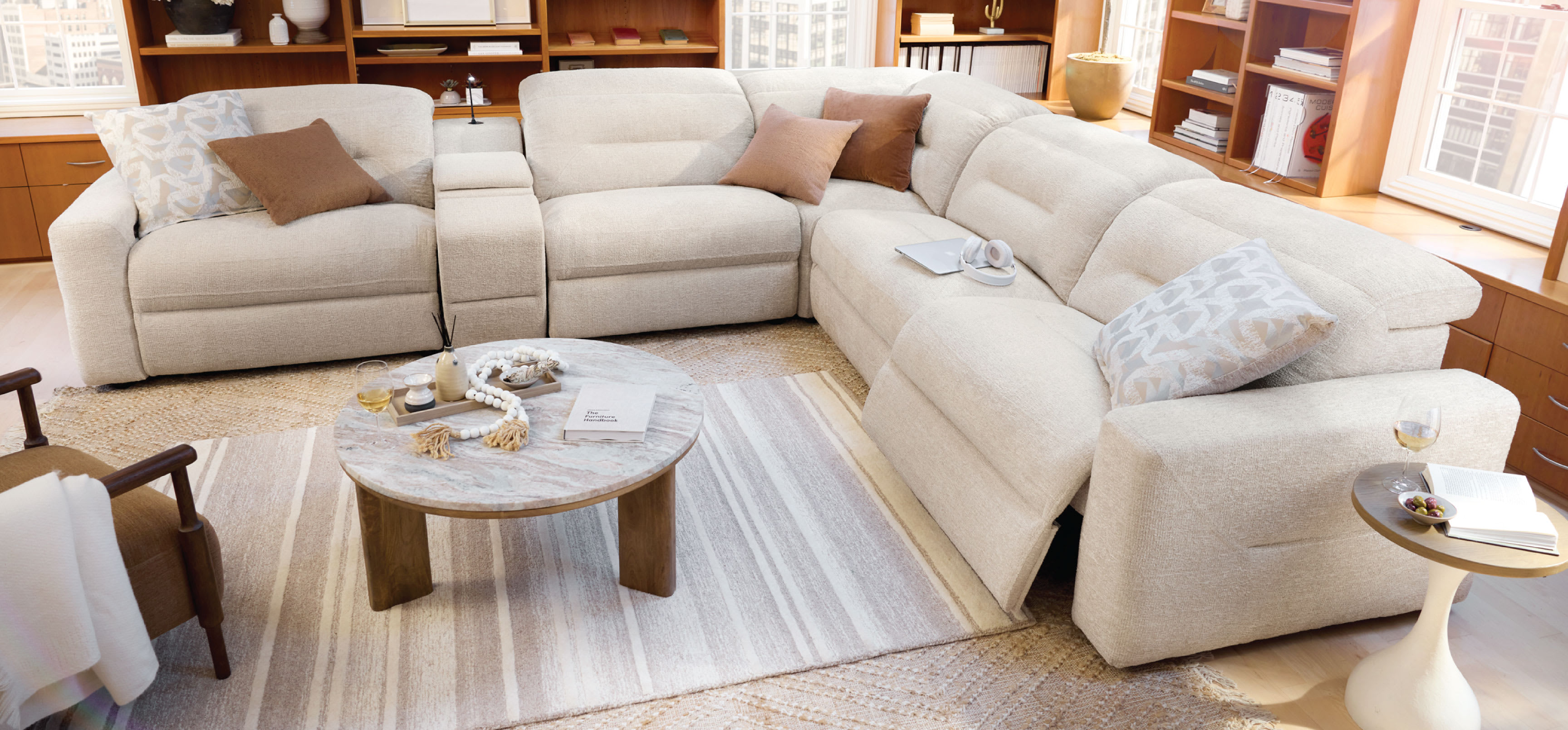 Living room featuring a white reclining sofa, rug, and wooden table.