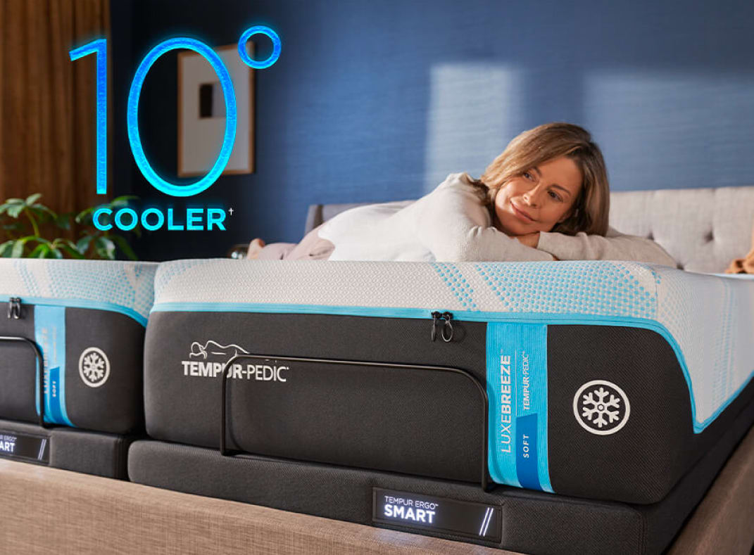 A woman lies  on her stomach across two Twin Xl Tempur Pedic mattresses. Overlaid on the image is 10° Cooler. Below the picture is a paragraph about sleeping too hot.