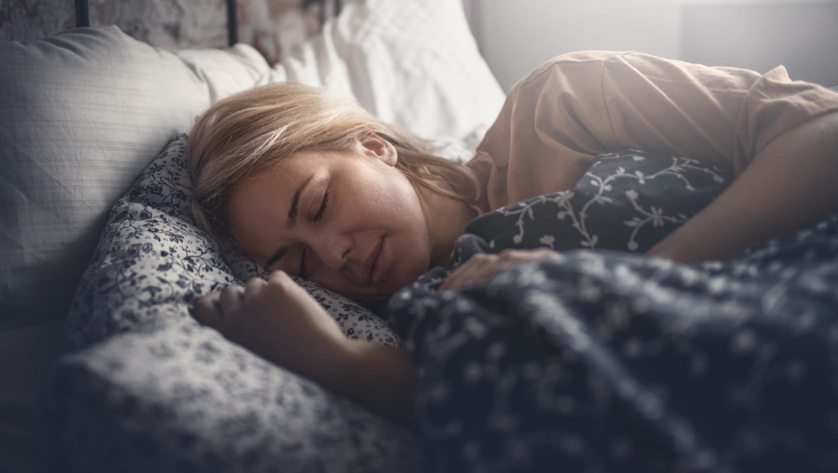 A woman laying on her side in bed sleeping