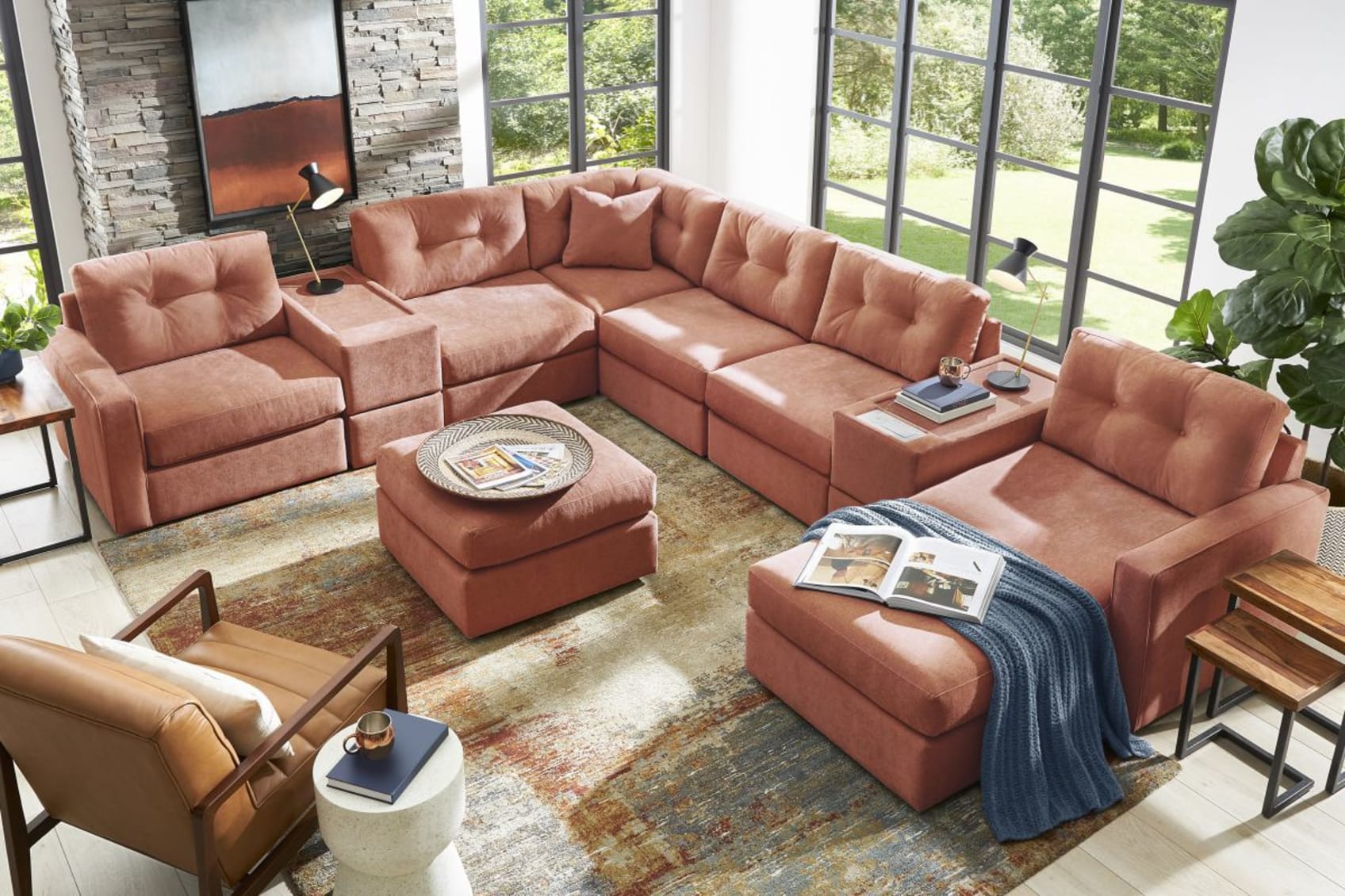 An orange colored upholstered sectional couch with matching ottoman.