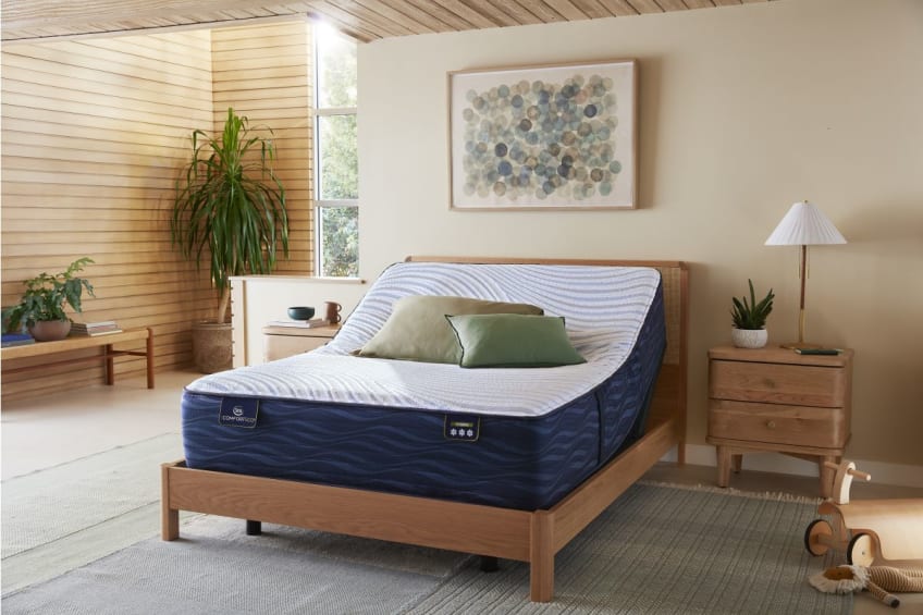 A Serta mattress atop an adjustable base in a bedroom.