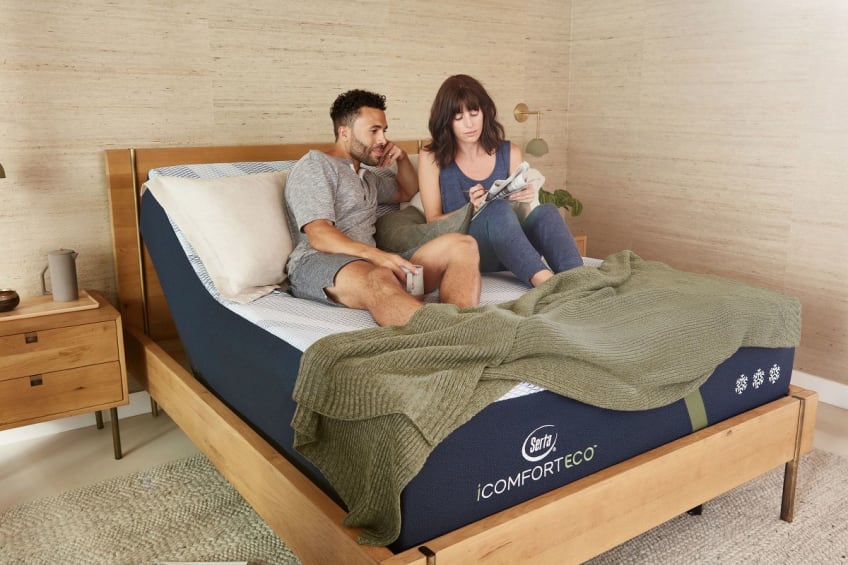 A man and a woman sitting atop an F30LTX mattress that's been angled up for a sitting position using an adjustable base.