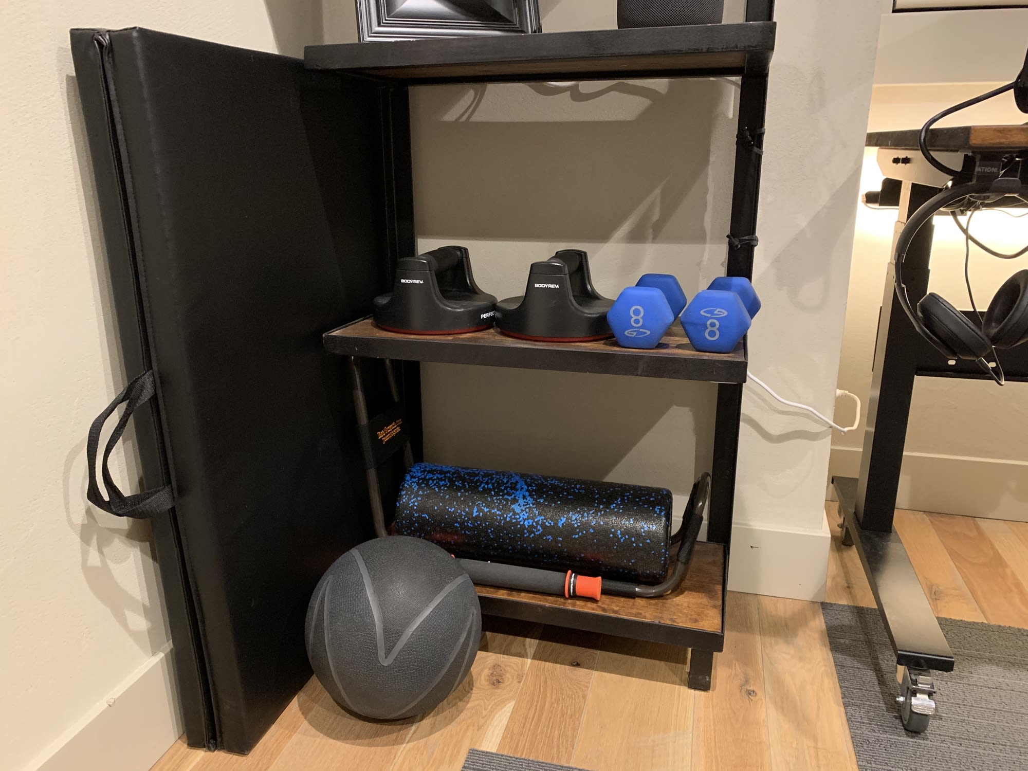 A photo of two shelves with some miscellaneous light fitness equipment.