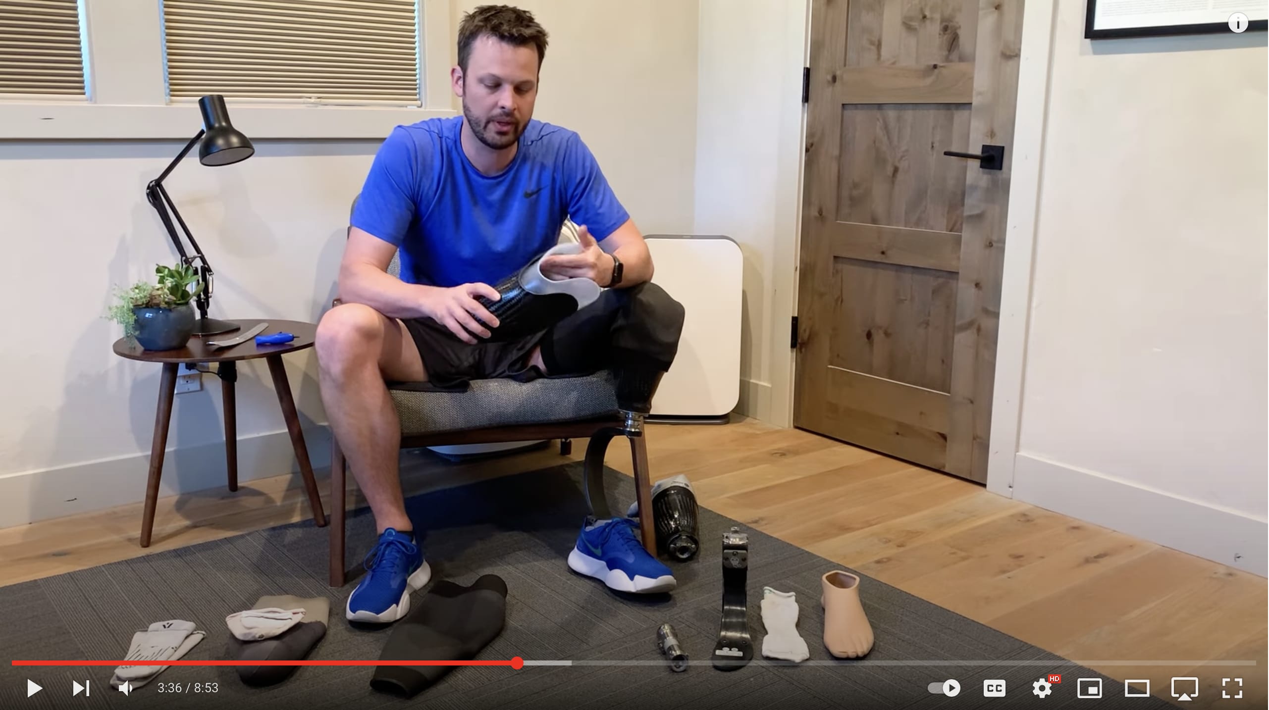 A screenshot of one of the early videos. It shows Garrett sitting at a chair with prosthetic equipment spread out in front of him. He's holding a socket and discussing how the parts work.