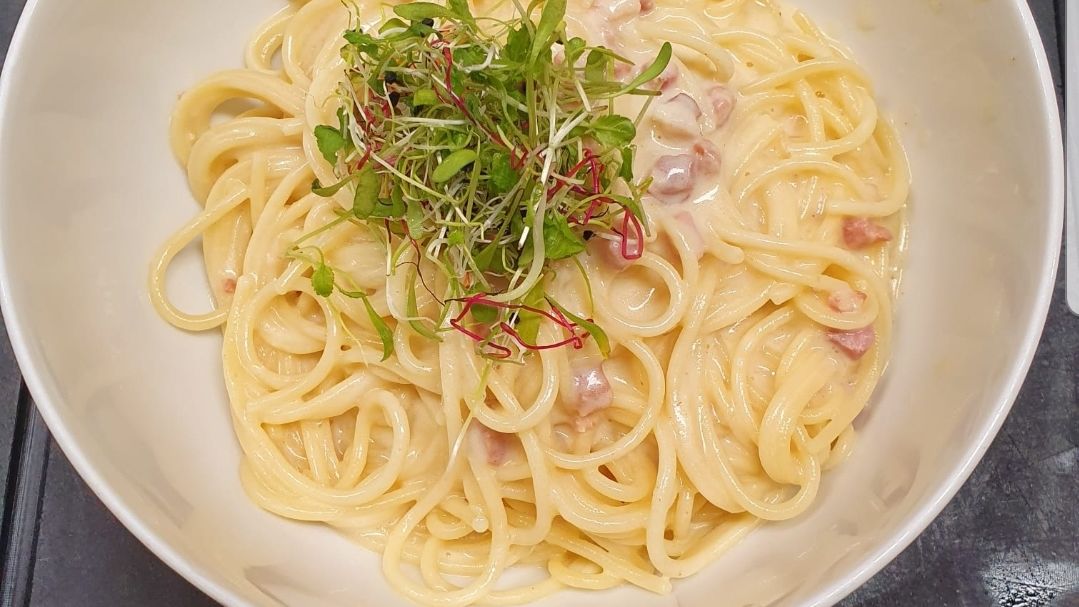 Spaghetti Carbonara mit Speck, Schinken, Reibkäse und Salat