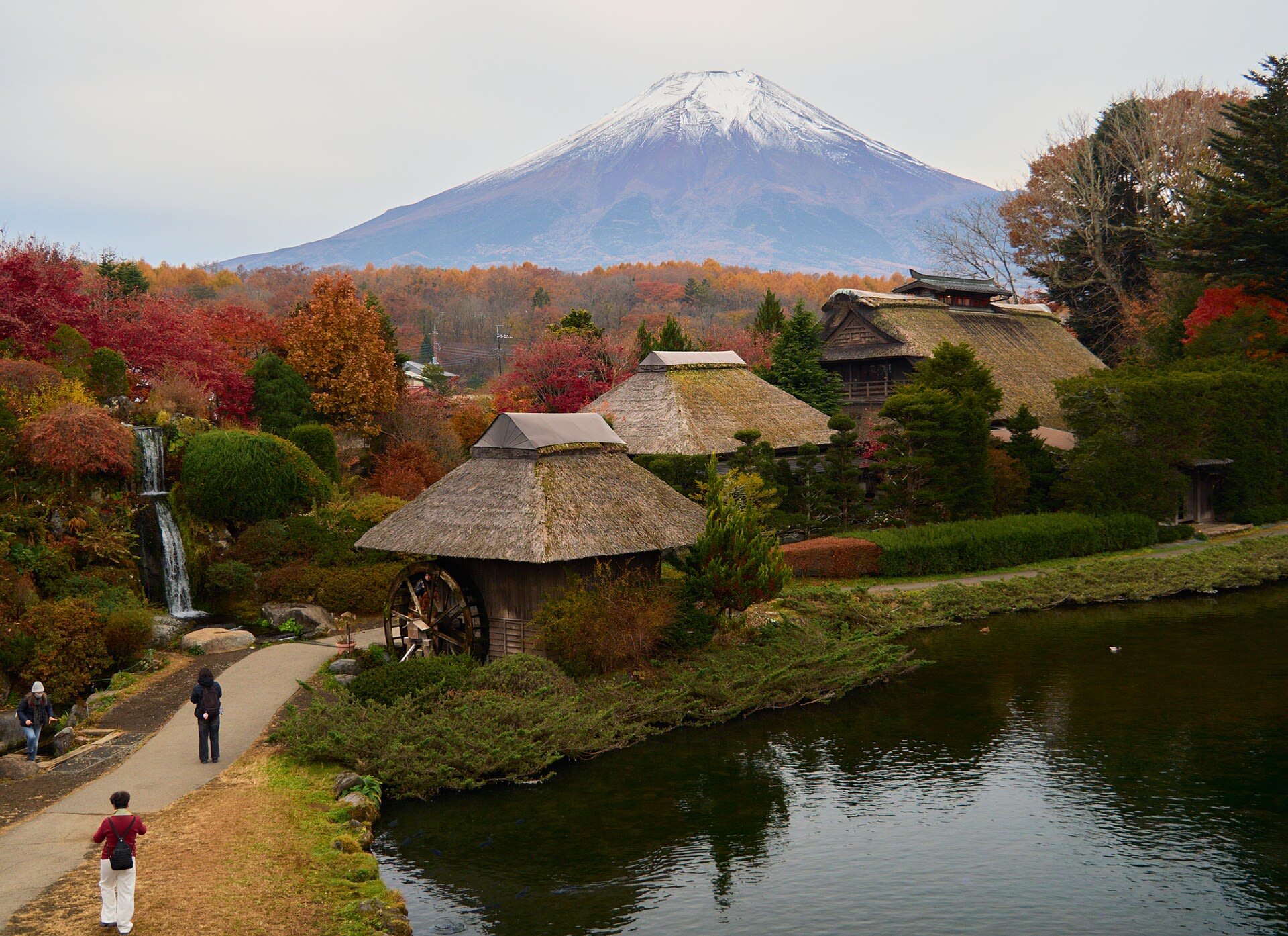 Traditional thatched-roof buildings with a waterwheel at Oshino Hakkai