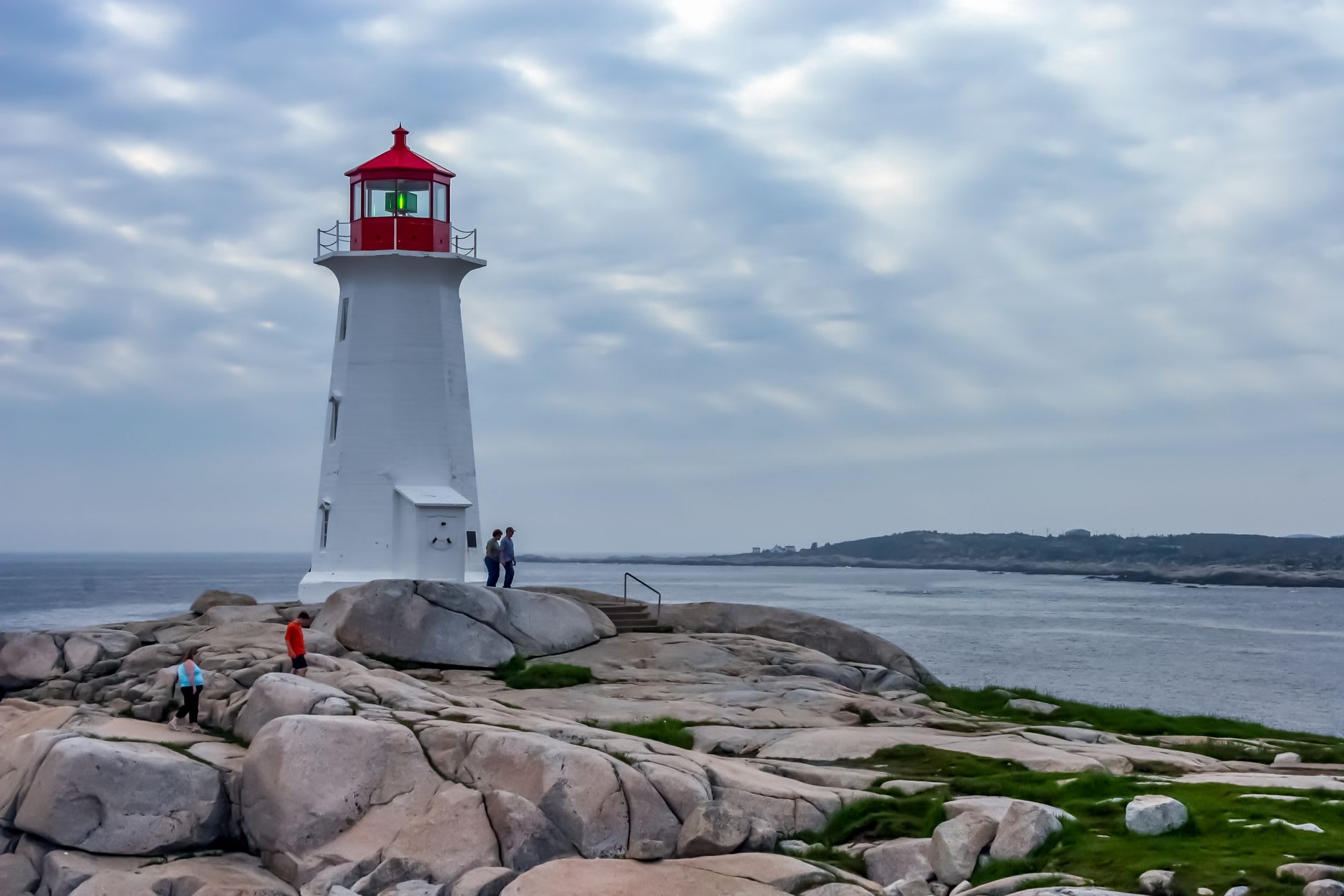 Red-and-white Peggy's Cove Lighthouse on granite rocks