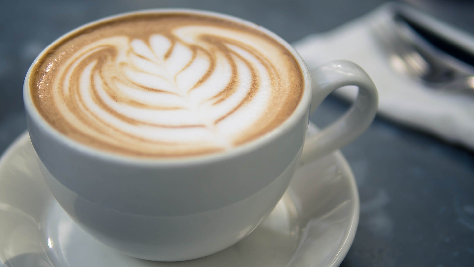 Cappuccino with latte art served in a white cup