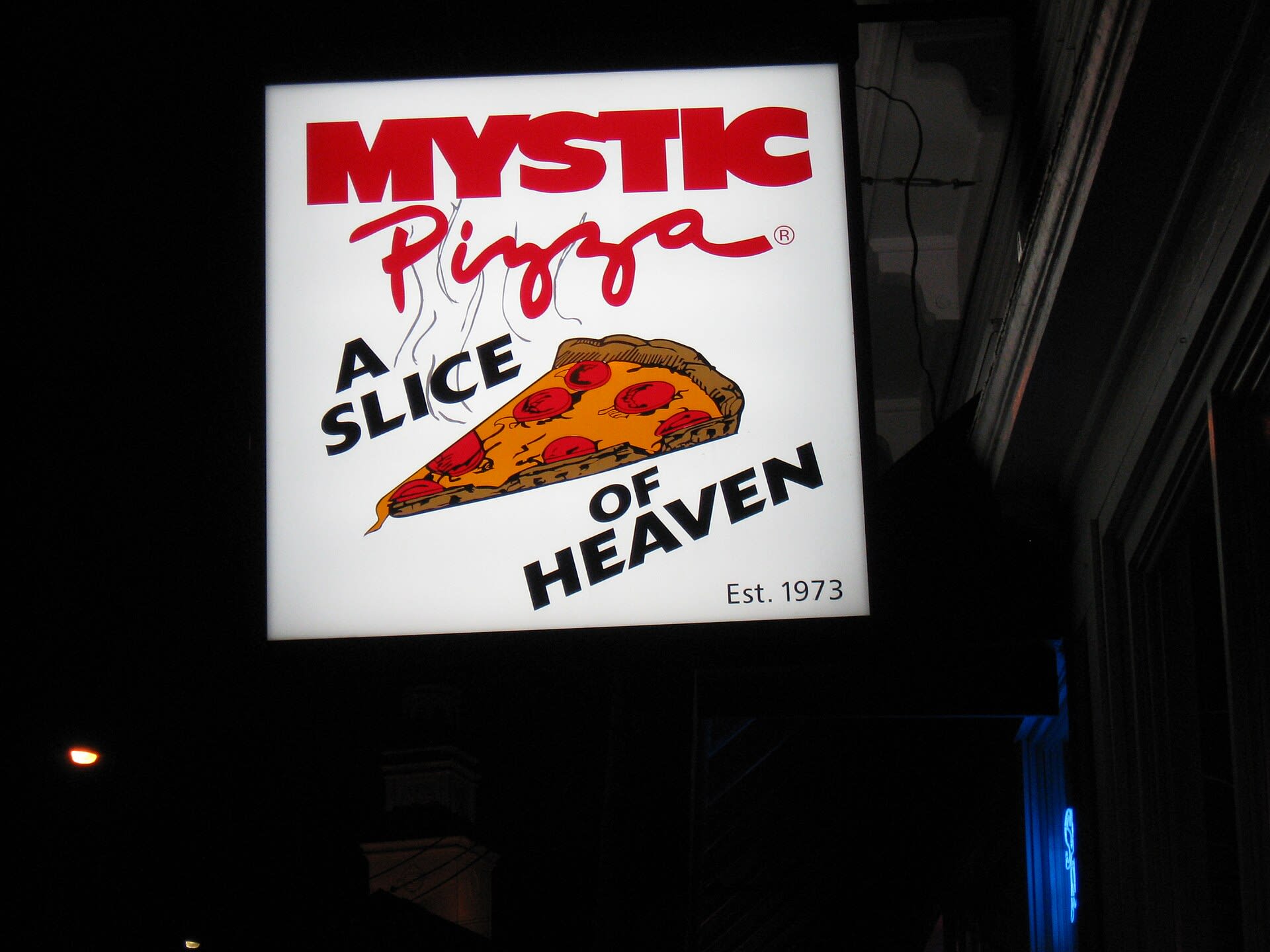 Slice of pizza from Mystic Pizza with a tabletop setting