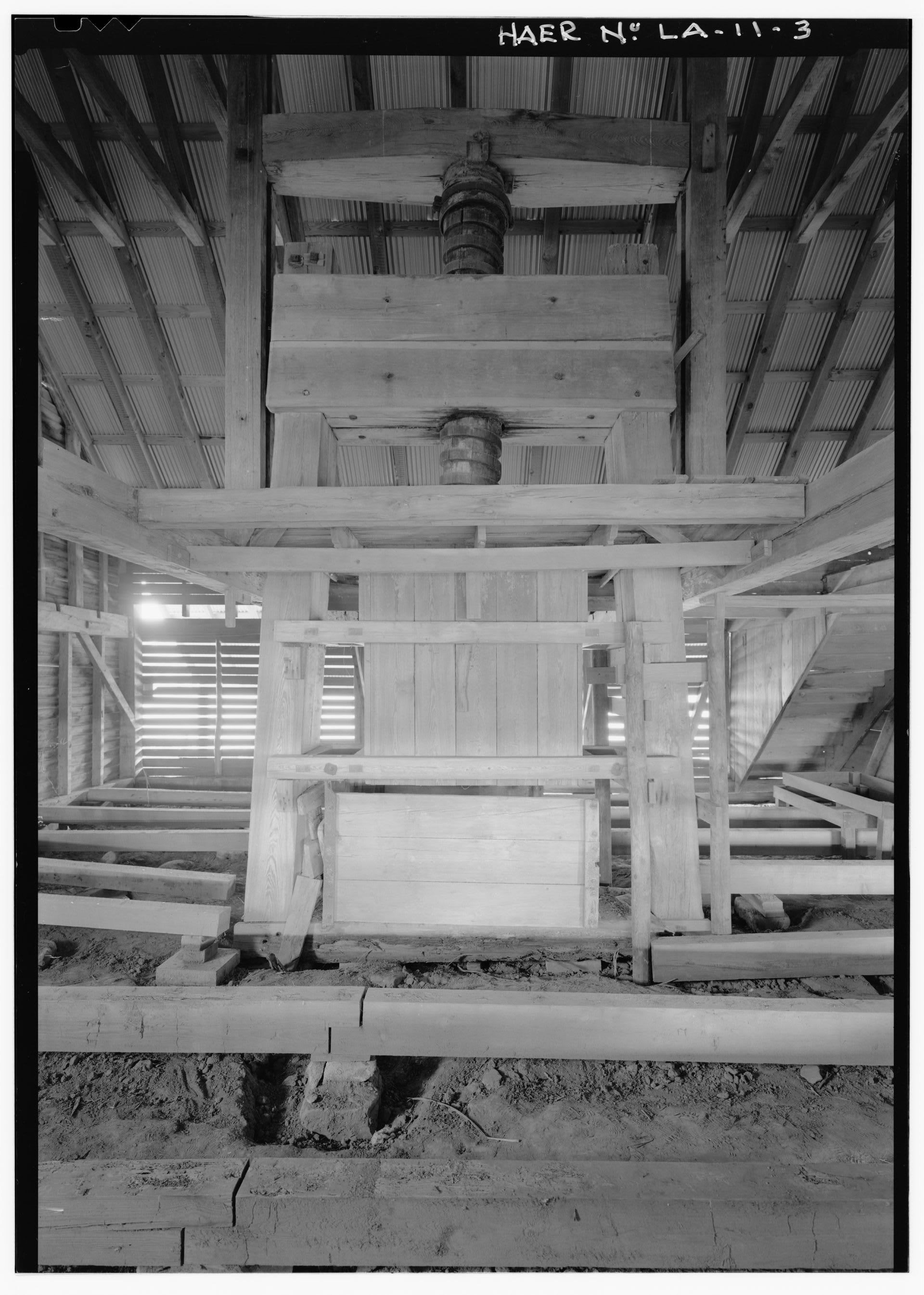 The wooden screw-type cotton press inside Magnolia Plantation's gin barn