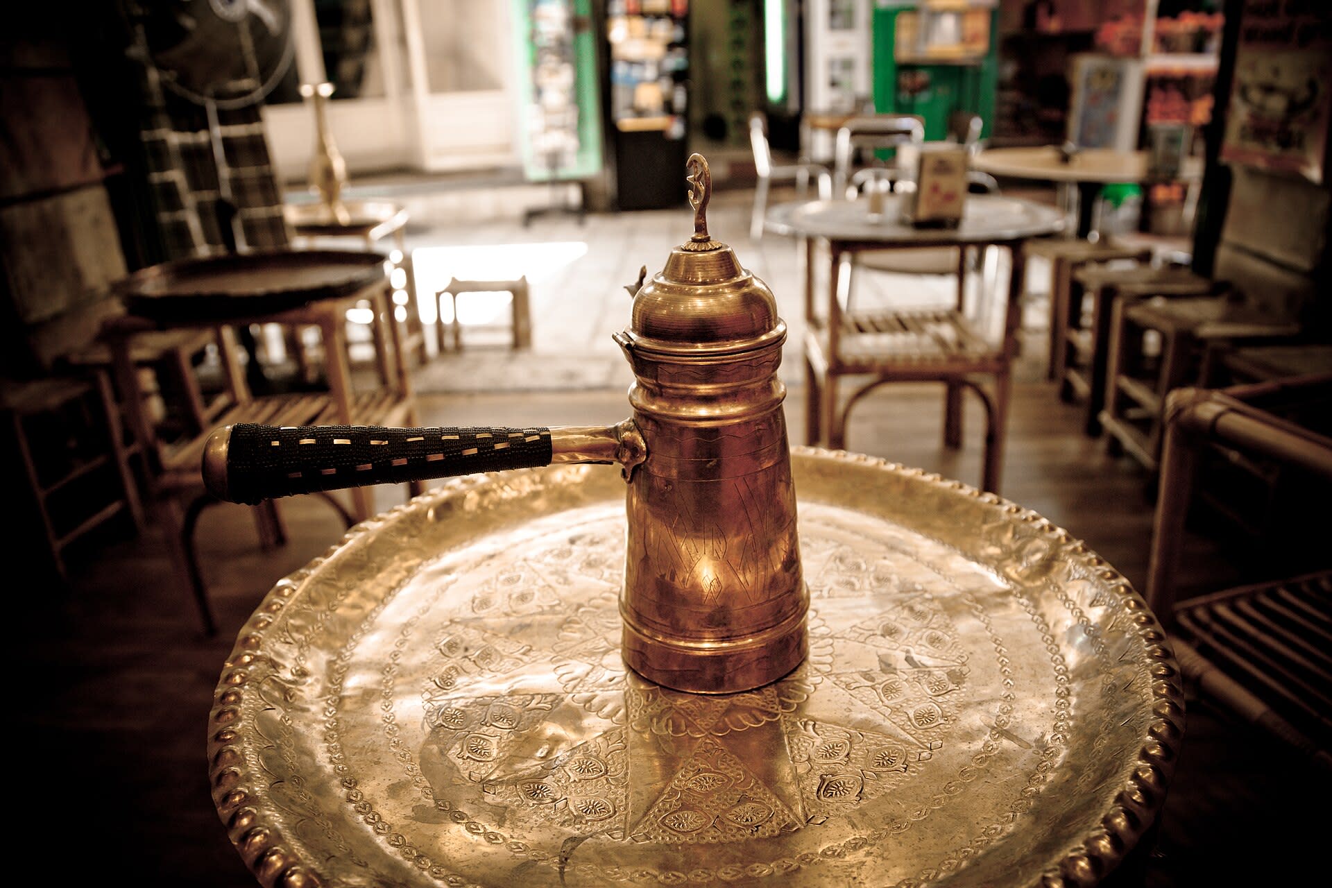 Copper cezve coffee pot brewing coffee in a small roadside coffee shop