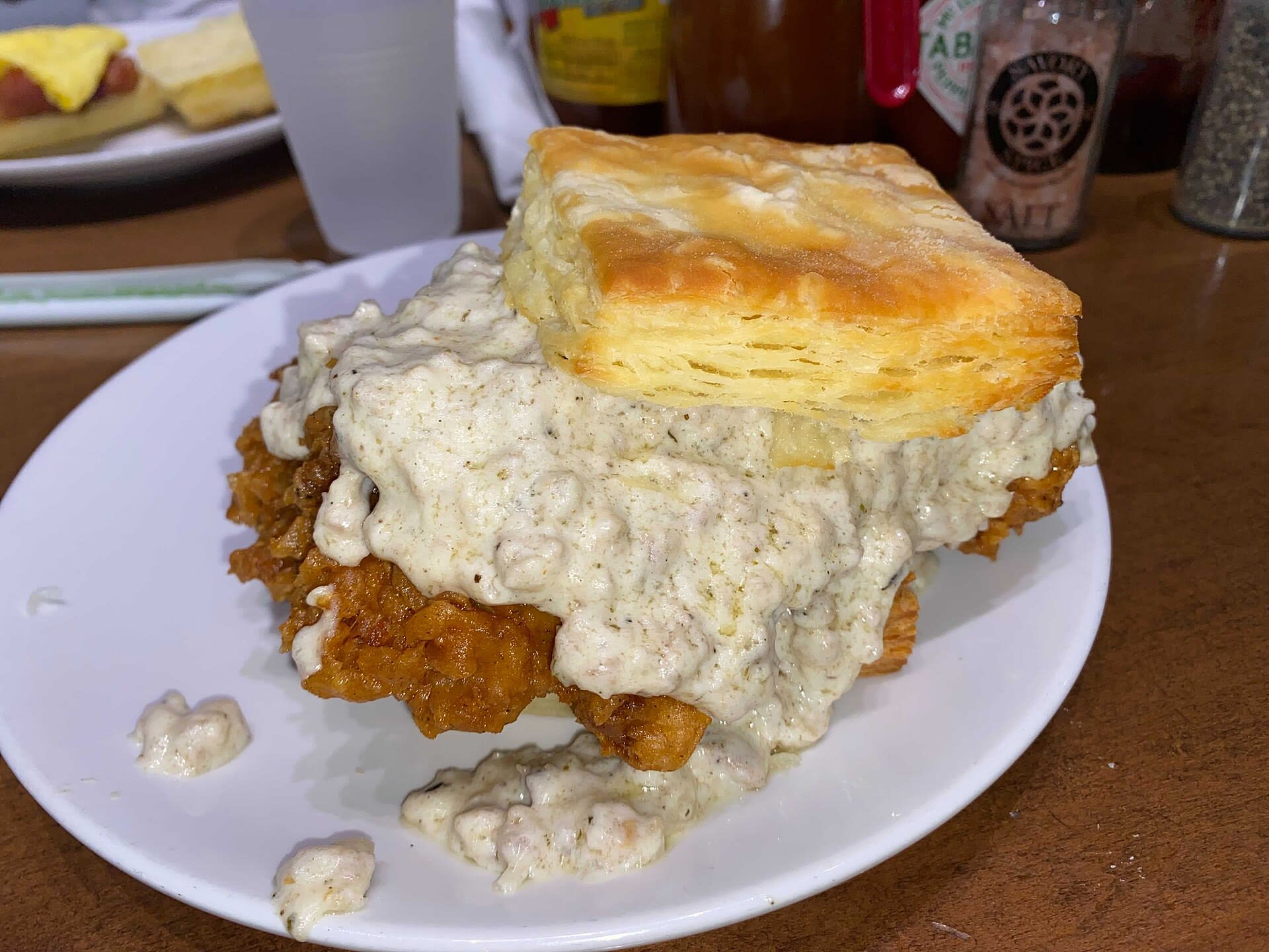 Fried chicken biscuit with sausage gravy at a restaurant