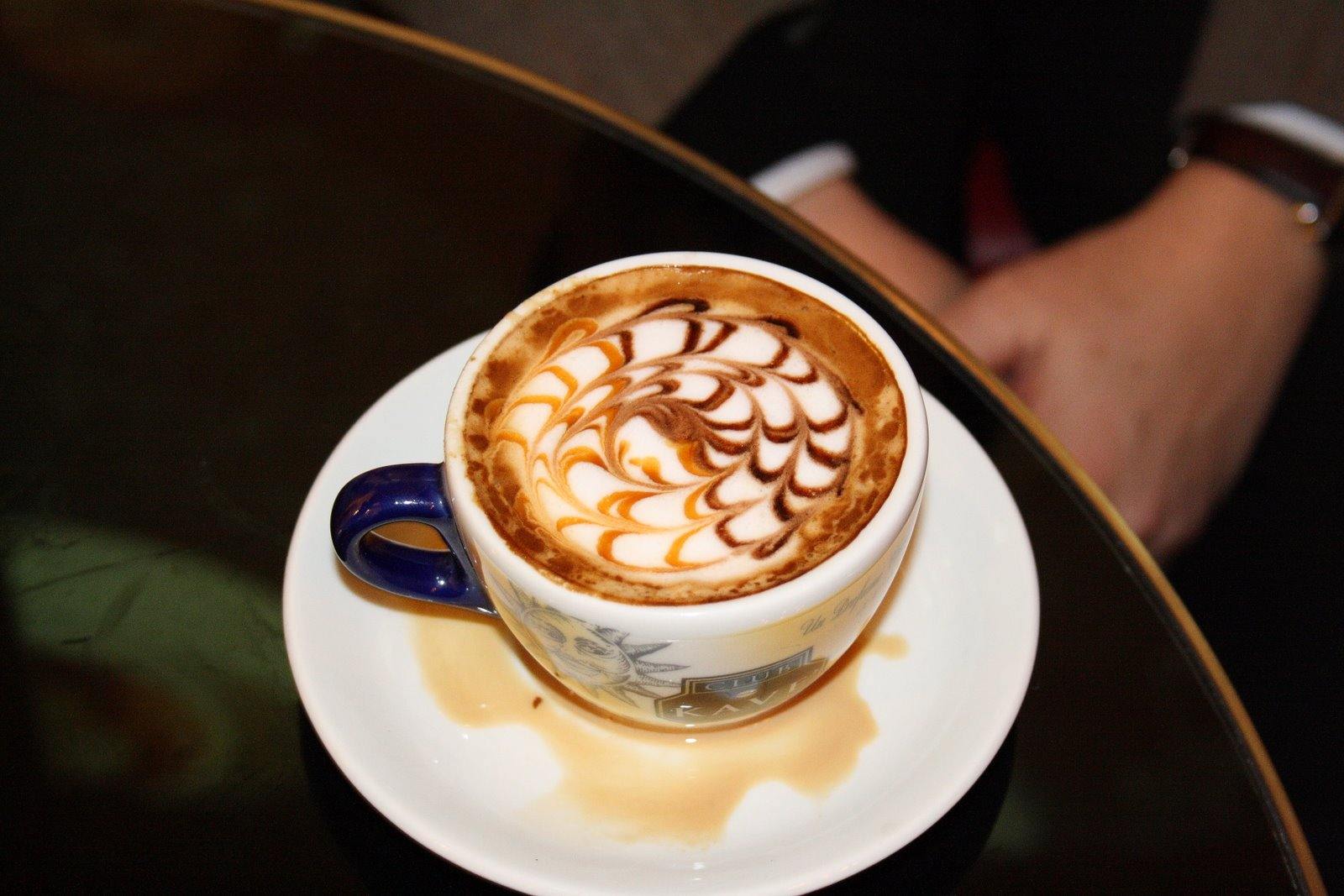 Cappuccino with latte art on a cafe table