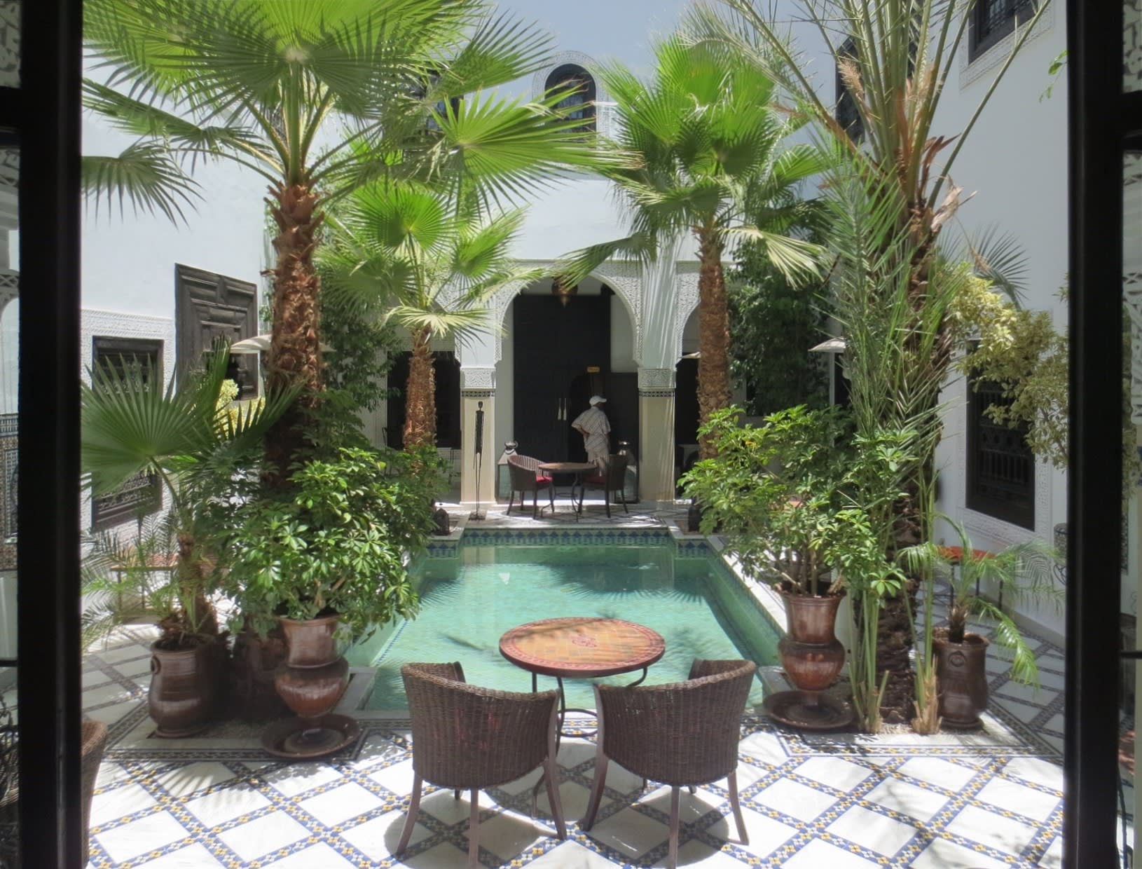 Traditional Moroccan riad courtyard with decorated walls and orange trees