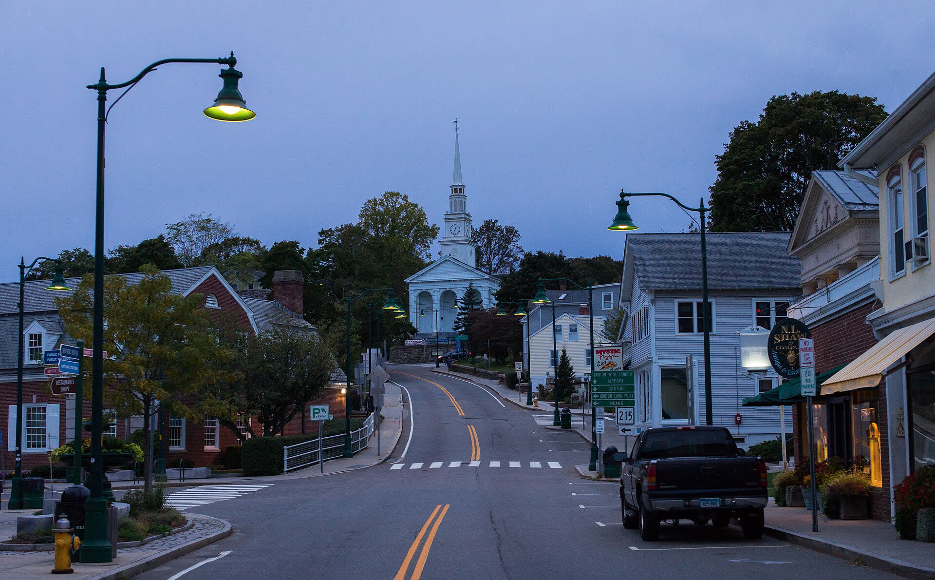 Mystic, Connecticut waterfront buildings and boats lit up during blue hour