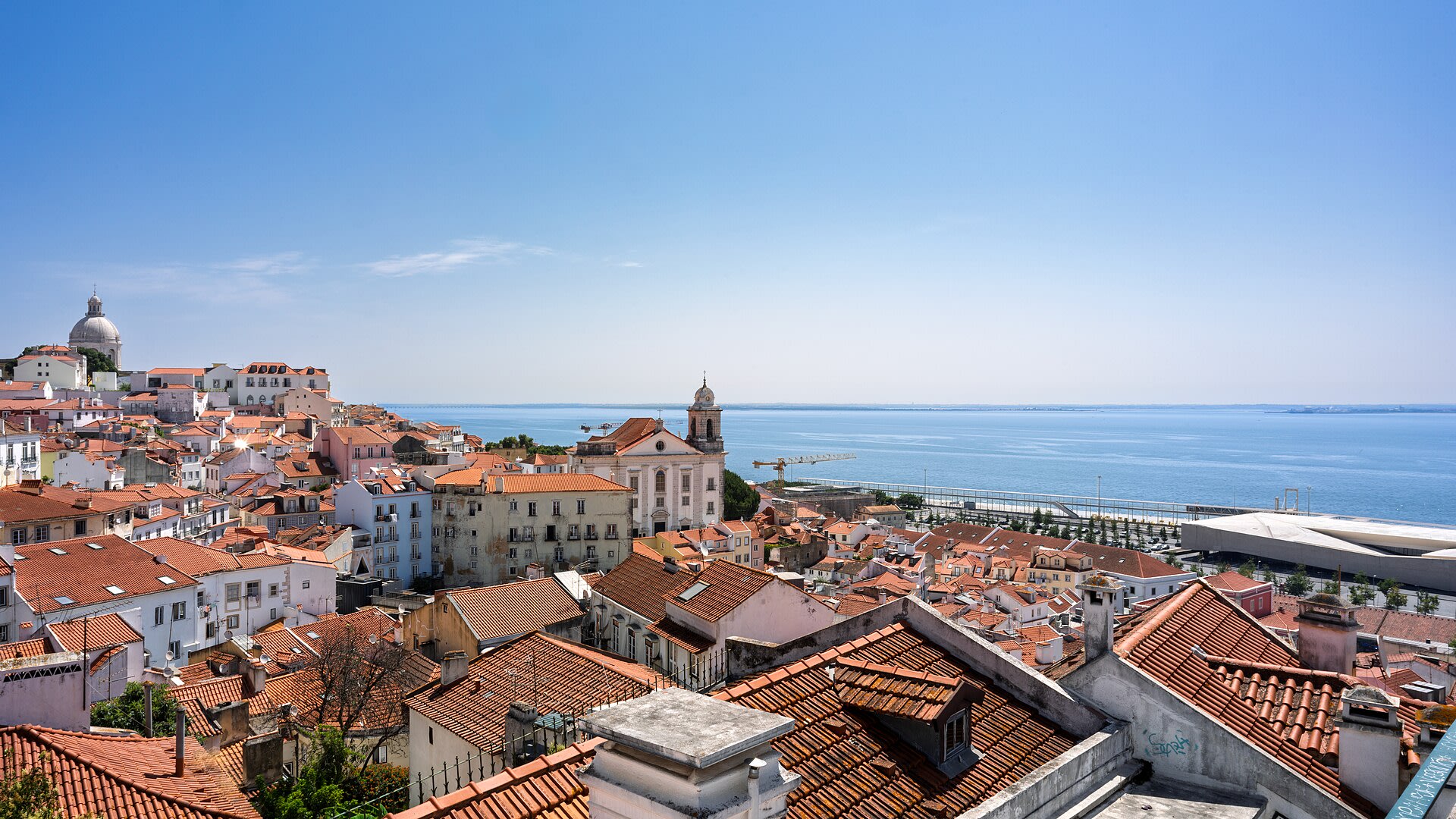Lisbon Alfama district rooftops stretching toward the Tagus River