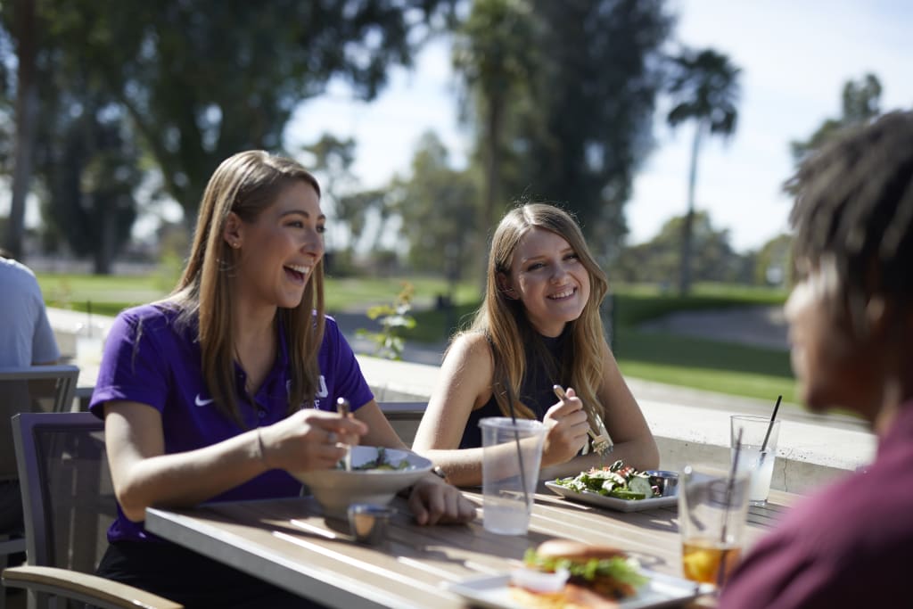 Two women enjoying food at GCU Golf Course Restaurant Lope House