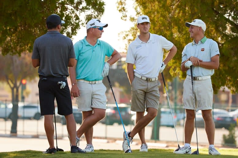 Four golfers standing and talking