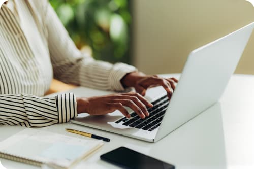 African American female hands in the process of typing on a laptop in an office setting
