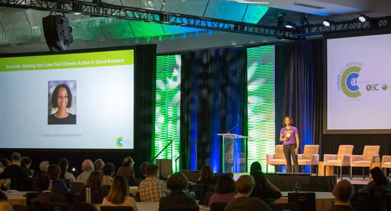 Carla giving a presentation on stage to the Climate Collaborative