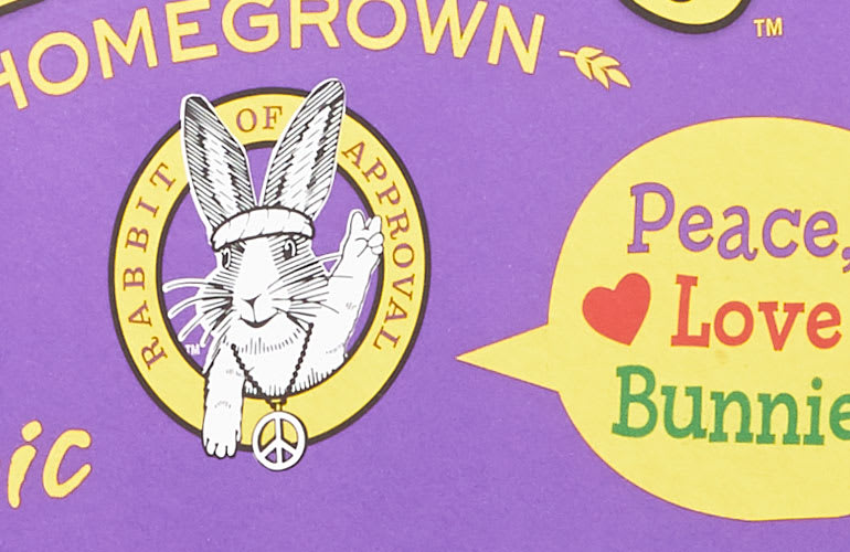 An illustrated bunny, wearing a headband and peace symbol necklace. It is holding up two fingers in a peace sign. A speech bubble reads "Peace., Love, Bunnies"