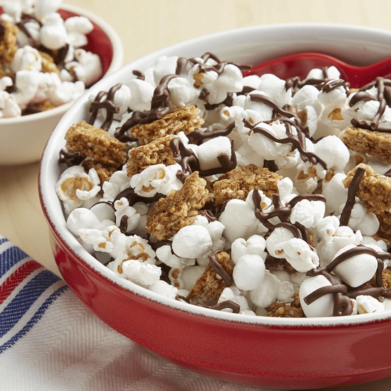 S'mores Popcorn Snack made with Nature Valley Oats 'N Honey Crunchy Granola Bars and marshmallows drizzled with melted semisweet chocolate chips.