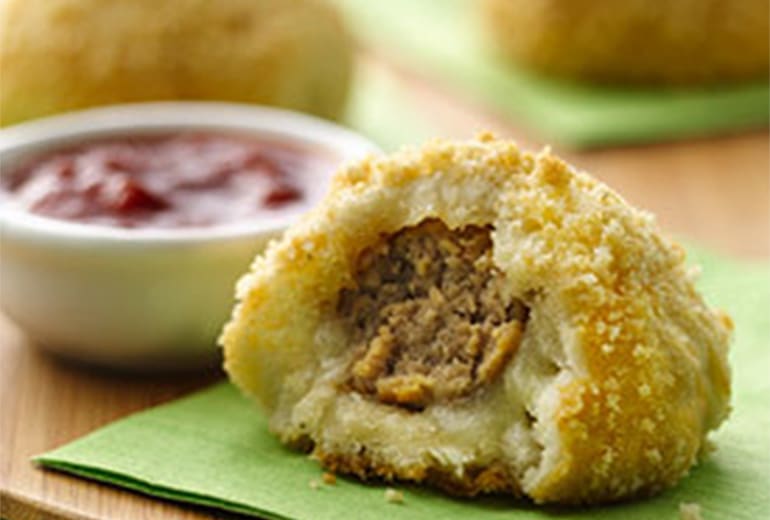 close up of a meatball pop with a bite taken out of it