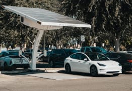 Imagen coche eléctrico cargando a través de paneles solares