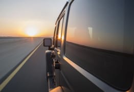 Van driving on road at sunset