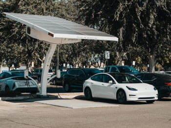 Imagen coche eléctrico cargando a través de paneles solares