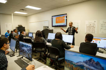 Learners in a classroom listening to an instructor