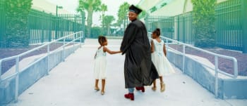 Female graduate walking with two little girls