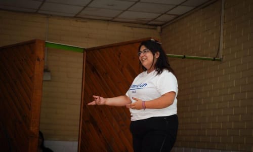 Illustration showing a woman breaking through a symbolic glass ceiling, representing leadership, progress, and economic mobility.