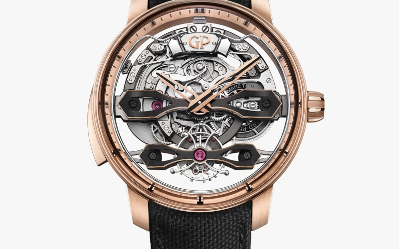 Rose gold wristwatch with a skeleton dial showing intricate mechanical gears and a black textured strap.