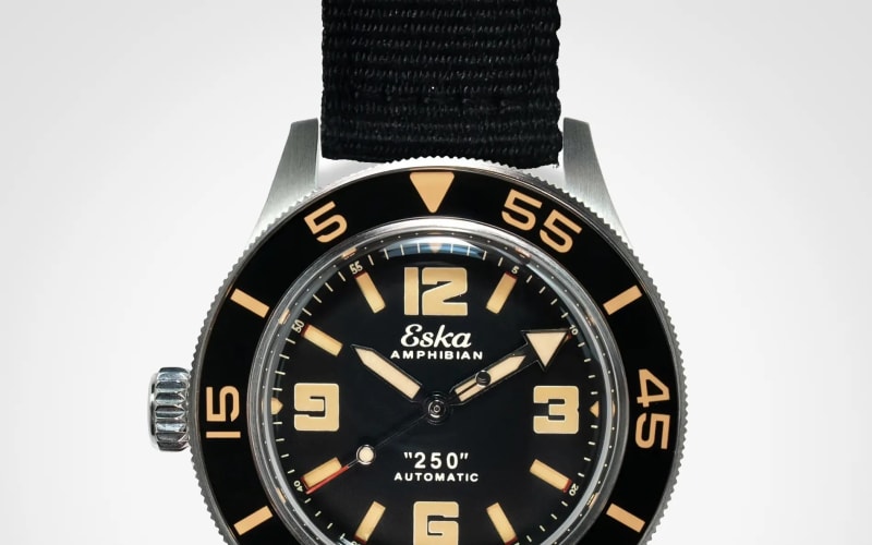 Black Eska Amphibian automatic dive watch with beige numerals and markers on a black fabric strap.