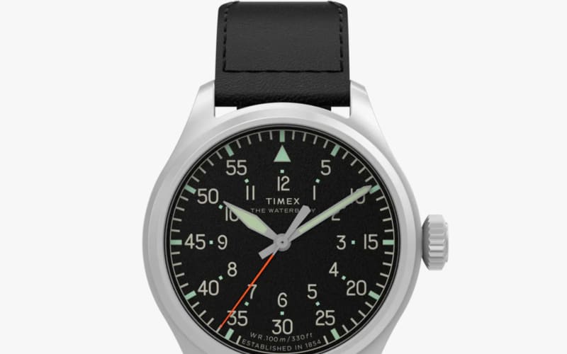Silver Timex wristwatch with black dial, white numerals, luminous hands, orange second hand, and black leather strap.