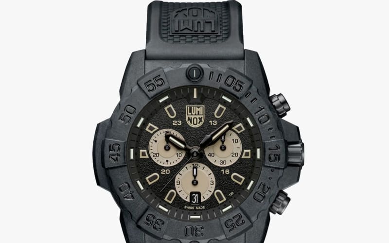 Black Luminox wristwatch with textured dial, beige subdials, rotating bezel, and black rubber strap.