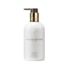 Molton Brownin vartalovoide (Milk Musk) valkoisessa pullossa, jossa on kultainen ja pronssinen pumppu, 300 ml.