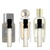 Parfumprøver i klare glasflasker med sorte sprøjtehoveder, trio sat mod større parfume flasker i baggrunden.