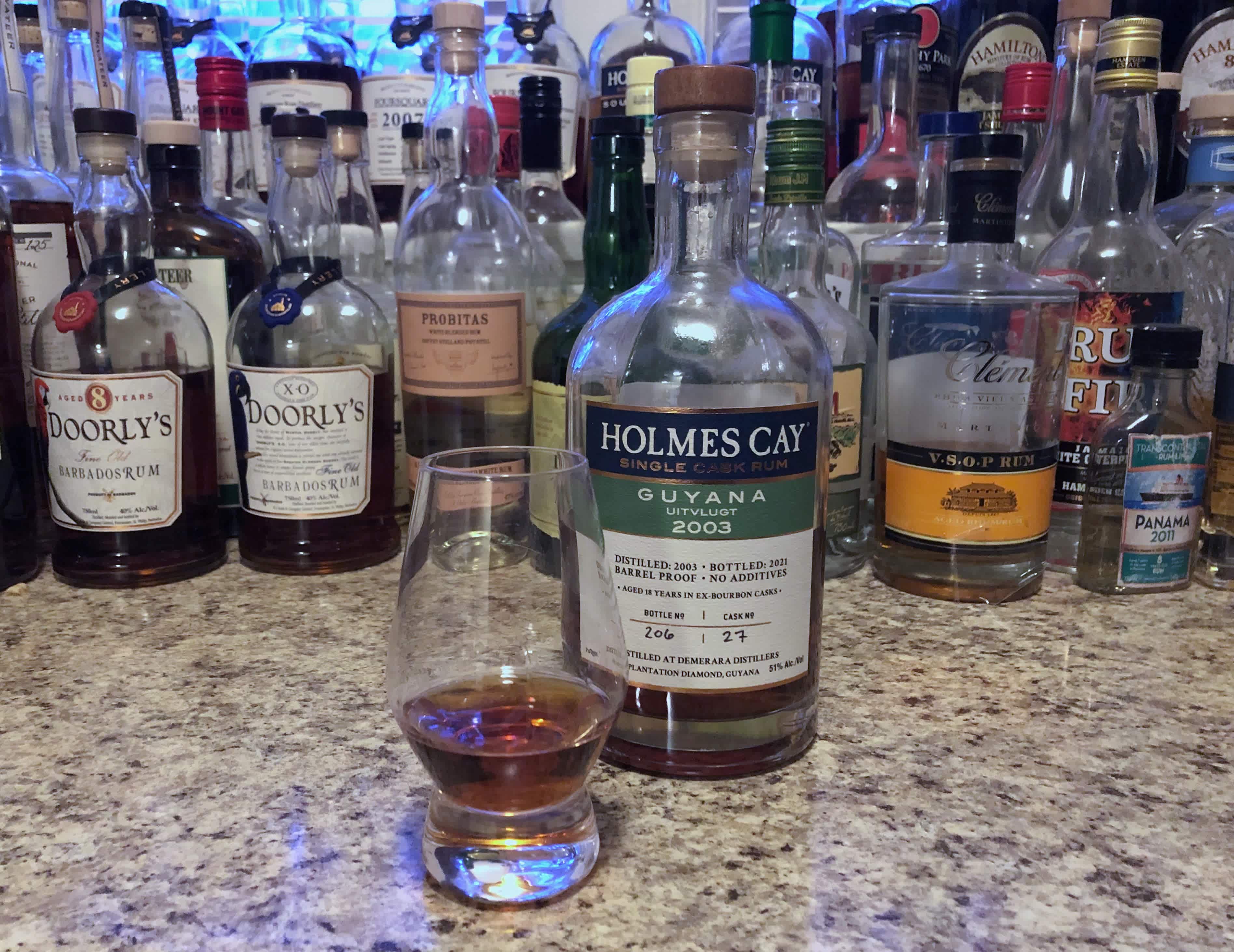 Bottle of Holmes Cay Guyana rum on a countertop next to a Glencairn of rum